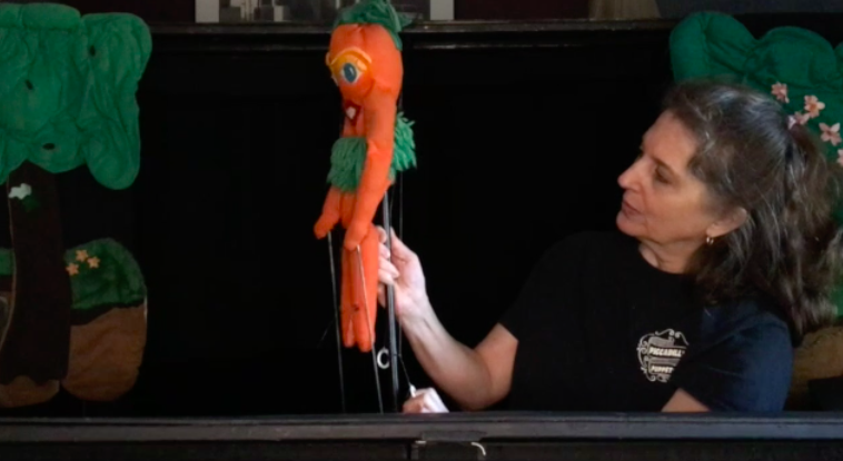 Puppeteer holding a carrot rod puppet